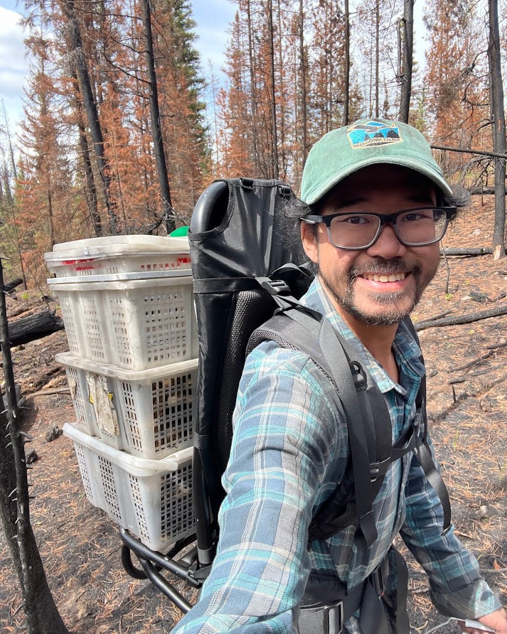Justin in the forest with a backpack and collecting baskets